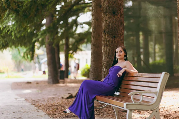 Mädchen im langen lila Kleid spaziert durch den Park — Stockfoto