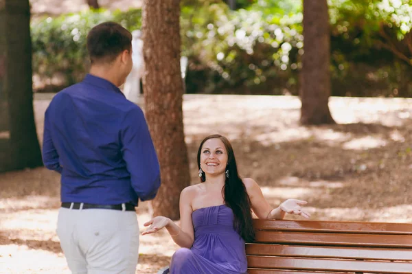 Girl in purple dress and a guy on a date in the park — Stock Photo, Image