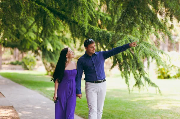 Pareja cariñosa en ropa púrpura caminando por el parque —  Fotos de Stock
