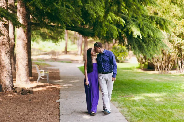 Pareja cariñosa en ropa púrpura caminando por el parque — Foto de Stock