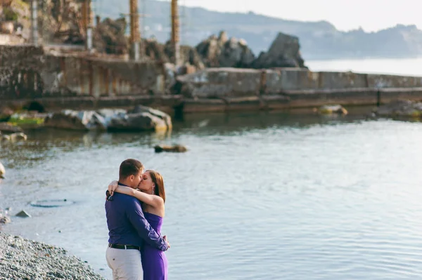 Una pareja amorosa en trajes púrpura en la orilla del mar —  Fotos de Stock