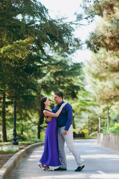 Älskande par i lila kläder promenader i parken — Stockfoto
