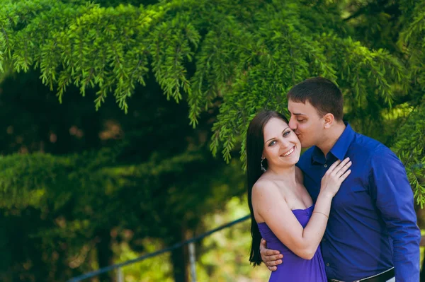 Loving couple in purple clothes walking in the park