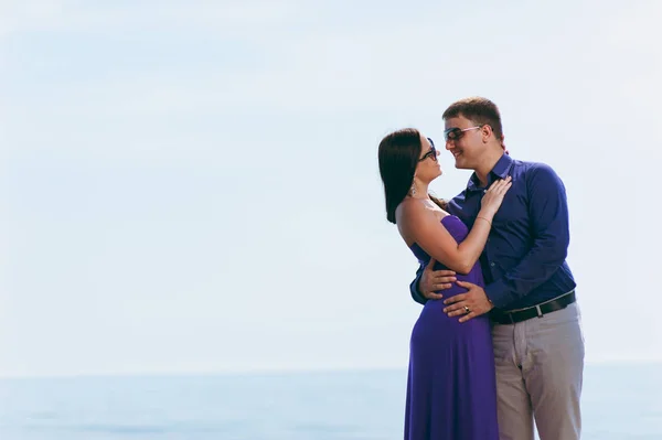 A loving couple in purple outfits on the seashore — Stock Photo, Image