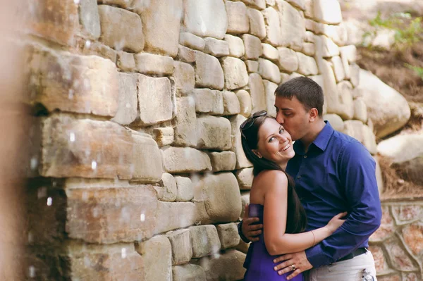 Casal apaixonado andando sobre pedras com água corrente — Fotografia de Stock