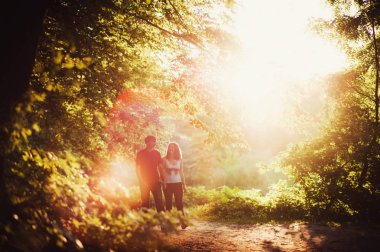 Birbirine aşık çiftler parkta yürürler.