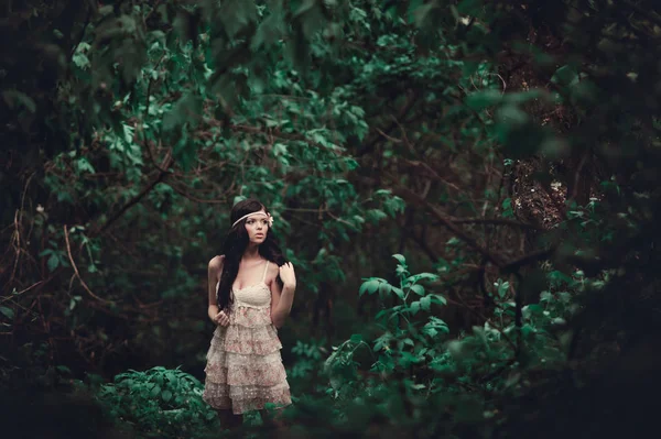 Brunette meisje in korte jurk in het bos — Stockfoto