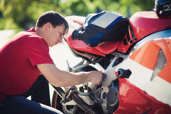 Kırmızı tişört adam bir motosiklet tamiri