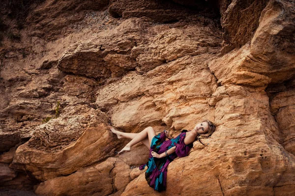 Menina em um vestido em uma rocha — Fotografia de Stock