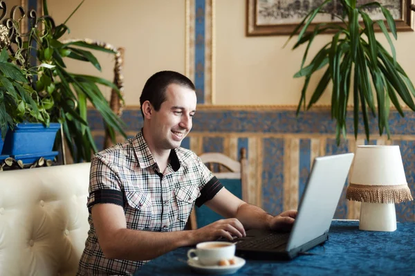 Чоловік працює в кафе на ноутбуці — стокове фото