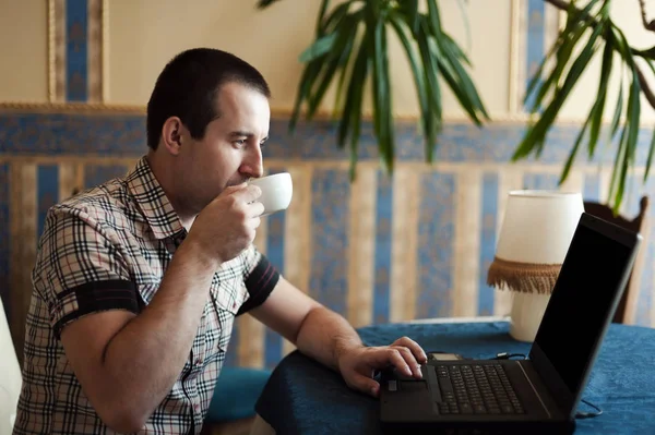 Homem trabalhando em um café em um laptop — Fotografia de Stock