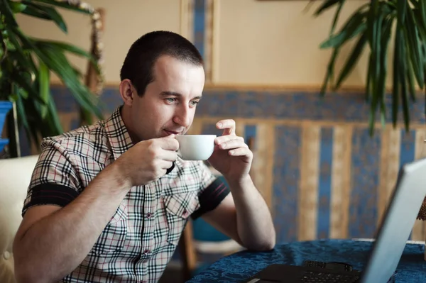 Uomo che lavora in un caffè su un computer portatile — Foto Stock