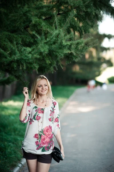 Blond dívka v výšivky poblíž kožešin strom na procházku — Stock fotografie