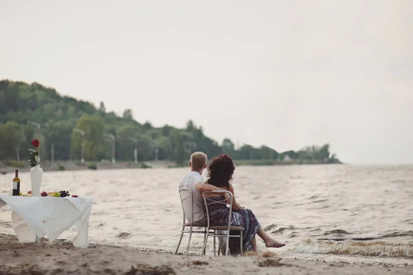 Par i kärlek samlades för att äta middag vid vattnet — Stockfoto