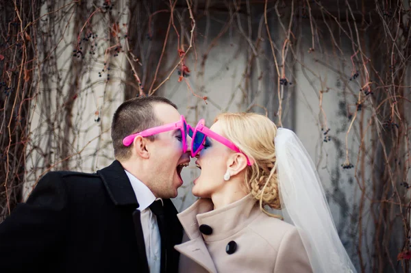 Alegre pareja de boda en gafas en forma de corazón —  Fotos de Stock