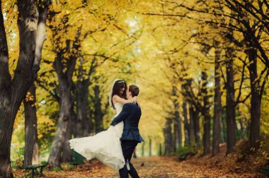 Güzel düğün çift sonbahar parkta bir yürüyüş üzerinde