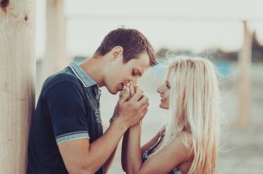 Genç aşık bir çift sahilde yürüyor.