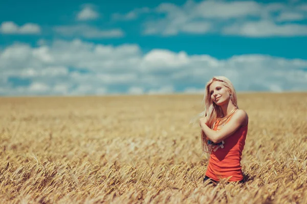 Blonde fille aux cheveux longs dans un champ de blé — Photo