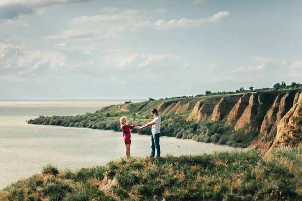 Pareja enamorada en un acantilado sobre el mar — Foto de Stock