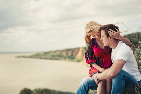 Par i kärlek på en klippa ovanför havet — Stockfoto