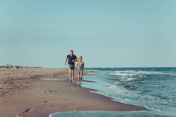 Jeune couple amoureux marchant sur la plage — Photo