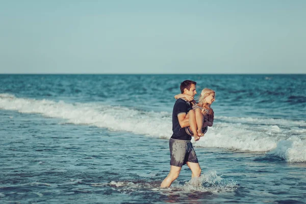 Jovem casal apaixonado andando na praia — Fotografia de Stock