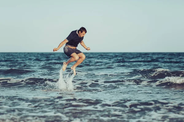 Un giovane salta e si diverte in mare — Foto Stock