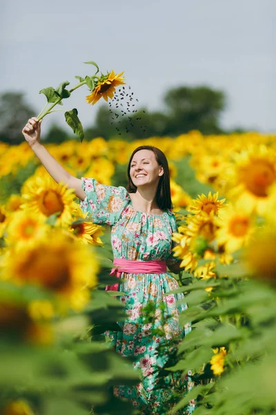 Bruna ragazza in un campo di girasoli come sotto la doccia — Foto Stock