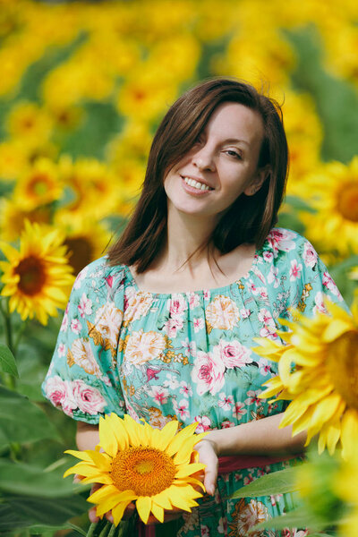 Brunette girl in a field of sunflowers