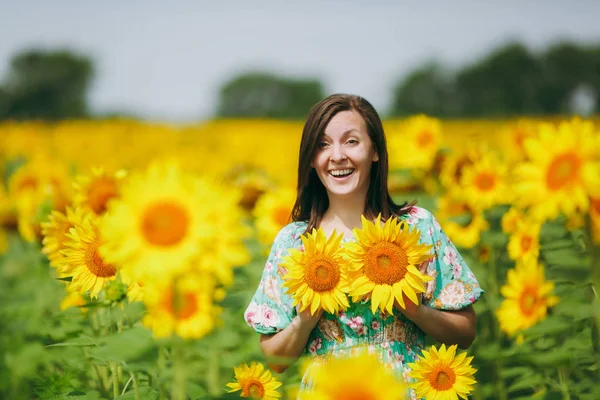 Flicka gäller solros blommor till sitt bröst — Stockfoto