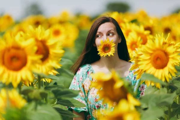 Brunett tjej i ett fält av solrosor — Stockfoto