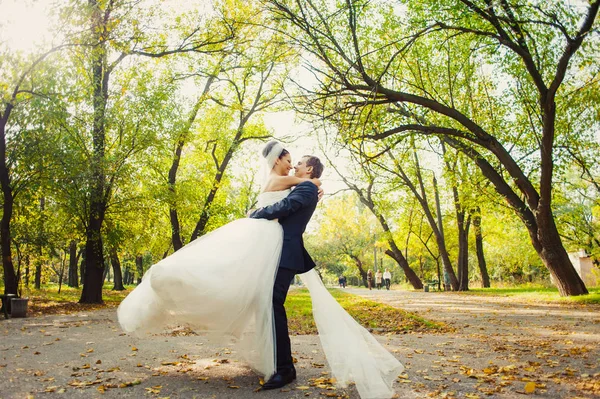 Liebendes Hochzeitspaar beim Spaziergang im Park — Stockfoto