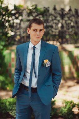 Parkta bir yürüyüş için takım elbiseli yakışıklı damat