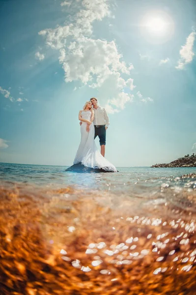 Loving wedding couple on a walk by the sea — Stock Photo, Image