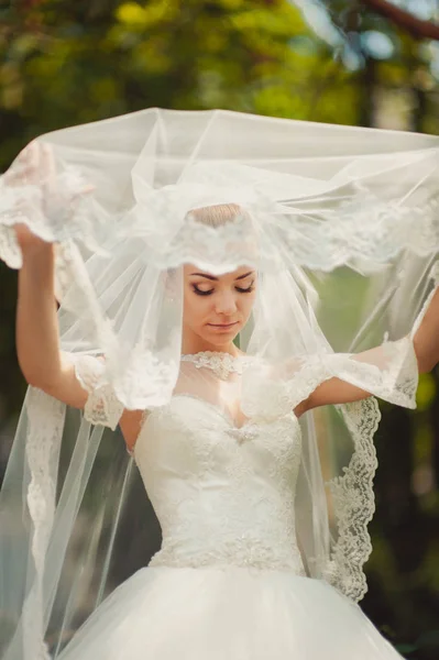 Sposa nascosta da un velo per una passeggiata nel parco — Foto Stock