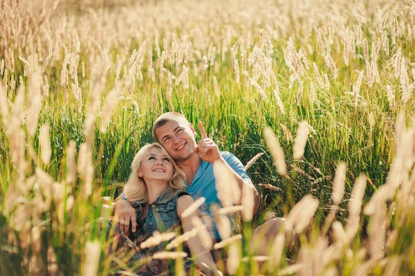 Unga älskande par i högt gräs utomhus — Stockfoto
