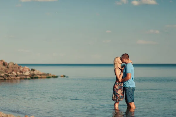 Молодая любящая пара целуется в море — стоковое фото