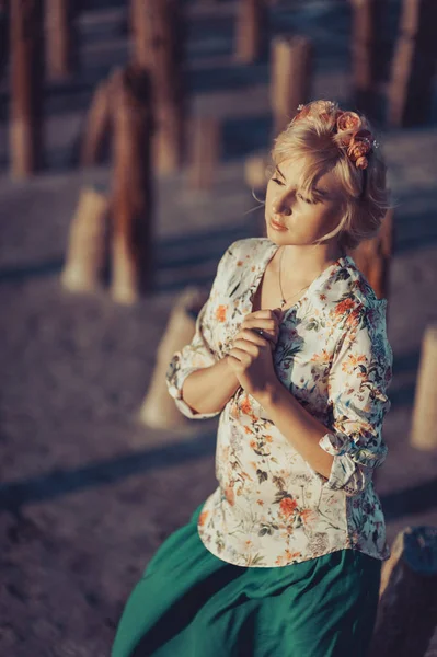 Красивая блондинка в венке для прогулки возле кирпича — стоковое фото