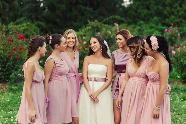 Noiva com damas de honra em vestidos rosa para um passeio — Fotografia de Stock