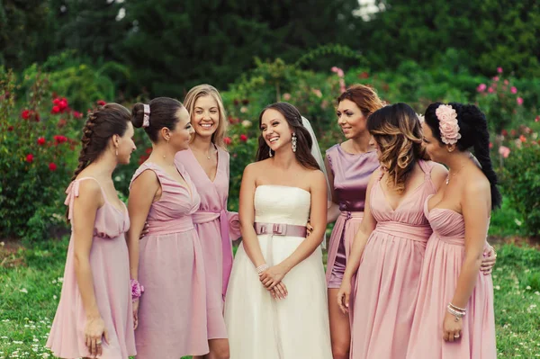 Novia con damas de honor en vestidos de color rosa para un paseo — Foto de Stock