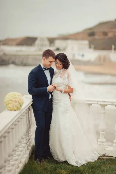 Hermosa pareja de boda en un paseo cerca del agua —  Fotos de Stock