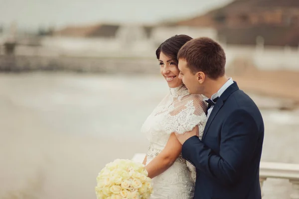 Hermosa pareja de boda en un paseo cerca del agua —  Fotos de Stock
