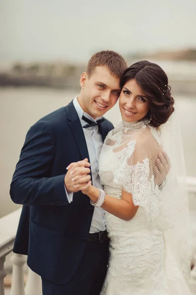 Beautiful wedding couple on a walk near water — Stock Photo, Image