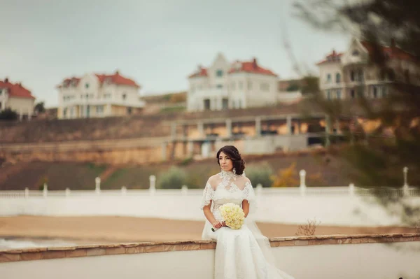 Όμορφη μελαχρινή νύφη σε ένα χώρο περιπάτου στην προκυμαία — Φωτογραφία Αρχείου