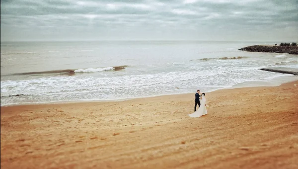 Beau couple de mariage sur une promenade près de l'eau — Photo