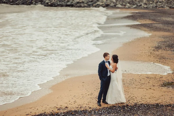 Beau couple de mariage sur une promenade près de l'eau — Photo