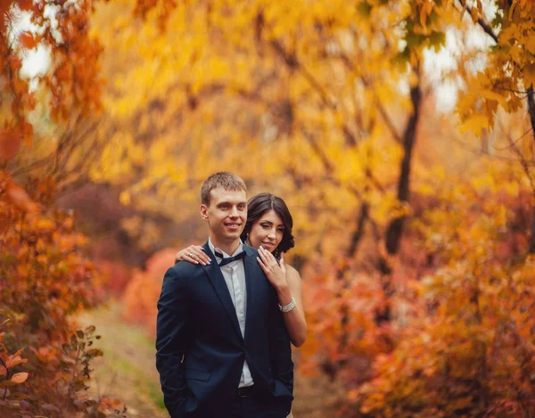 Свадебная пара на прогулке в осеннем парке — стоковое фото