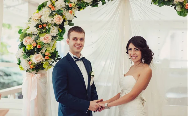 Bride and groom put rings on each other and show them at the ceremony — Stock Photo, Image