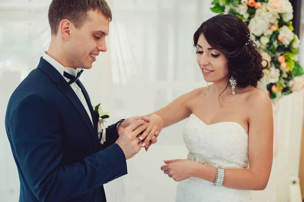 Bride and groom put rings on each other and show them at the ceremony — Stock Photo, Image