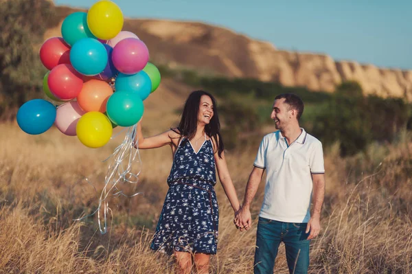 Casal apaixonado por um passeio na natureza com balões — Fotografia de Stock